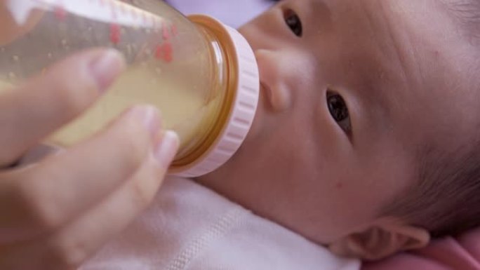 婴儿在婴儿奶瓶中喝牛奶
