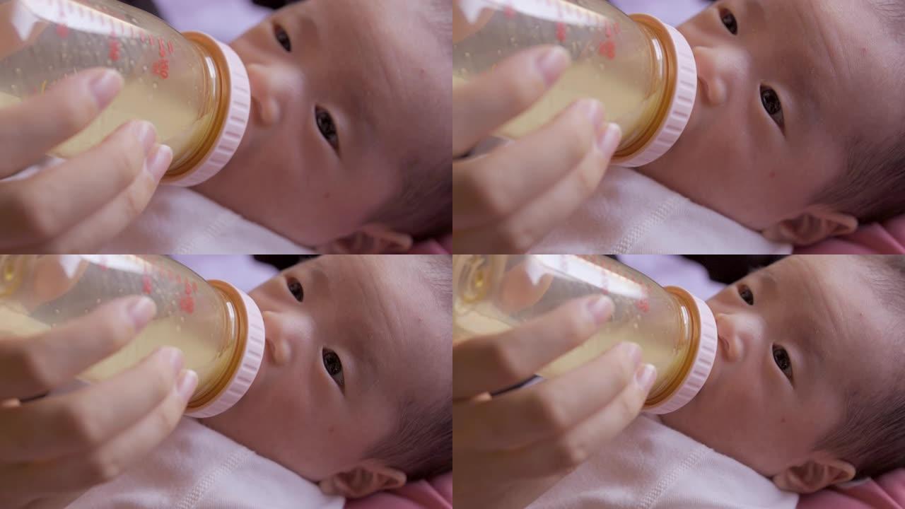 婴儿在婴儿奶瓶中喝牛奶