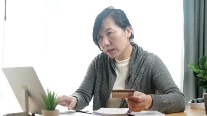 亚洲女性填写信用卡号码在家网上购物，生活方式概念。