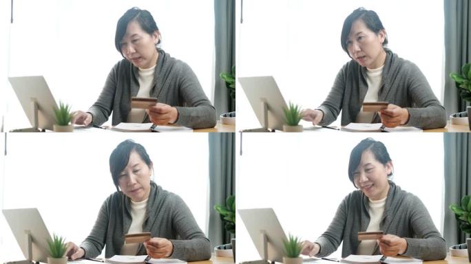 亚洲女性填写信用卡号码在家网上购物，生活方式概念。