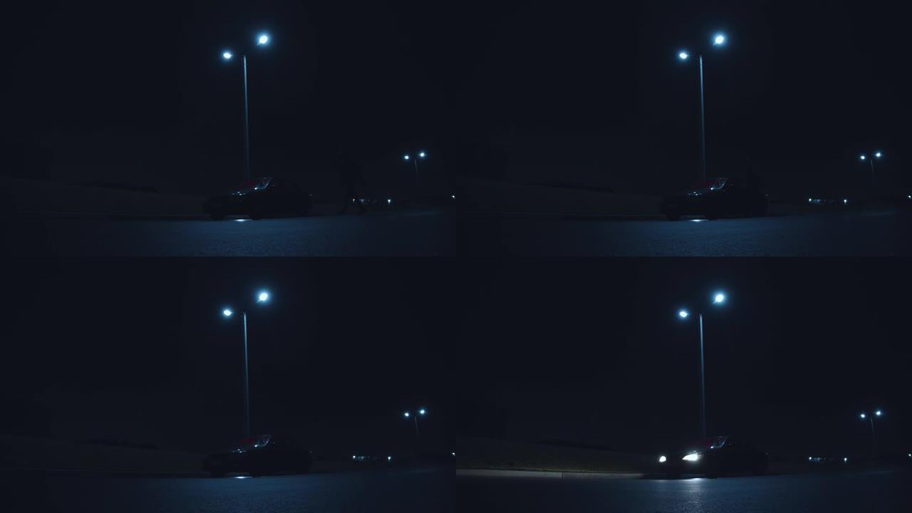 身份不明的男子坐在黑暗的停车场上，打开大灯，危险