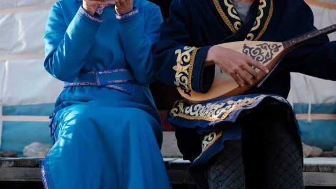 穿着亚洲衣服的夫妇坐在蒙古包附近