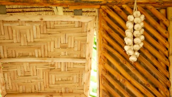 墙上的一堆大蒜。一堆干大蒜挂在传统亚洲房子的竹墙上