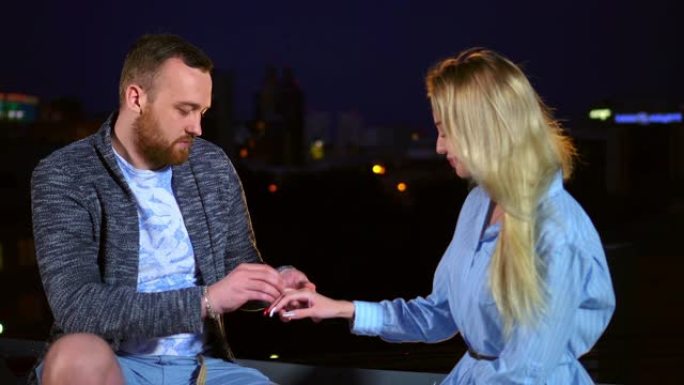 人们在夜城求婚结婚女孩，并在女性手指4K上戴上戒指。