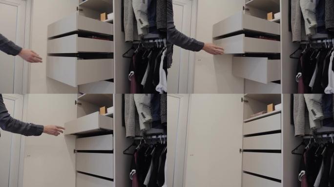 一名男子用衣服关闭衣柜里的架子