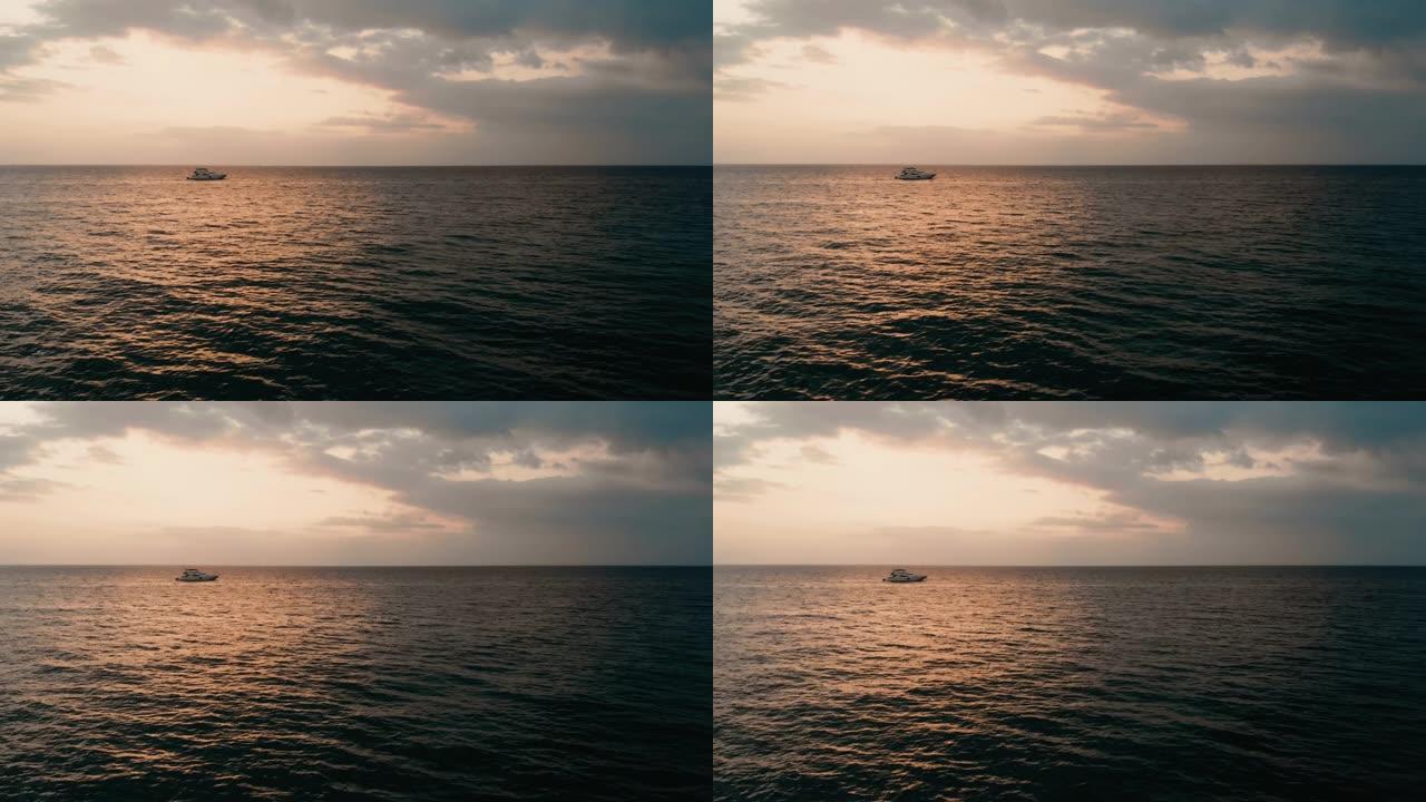 海面上五颜六色的日落，阳光明媚，地平线上有帆船。水面上反射的太阳和宽阔的阳光。海景和旅行的概念。空中