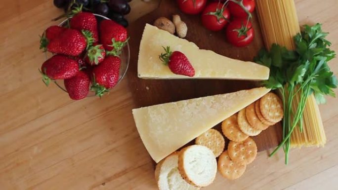 木制背景上的有机奶酪、水果、坚果奶酪拼盘。从上方观看。草莓。美味的奶酪小吃。