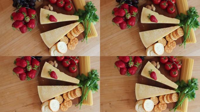 木制背景上的有机奶酪、水果、坚果奶酪拼盘。从上方观看。草莓。美味的奶酪小吃。