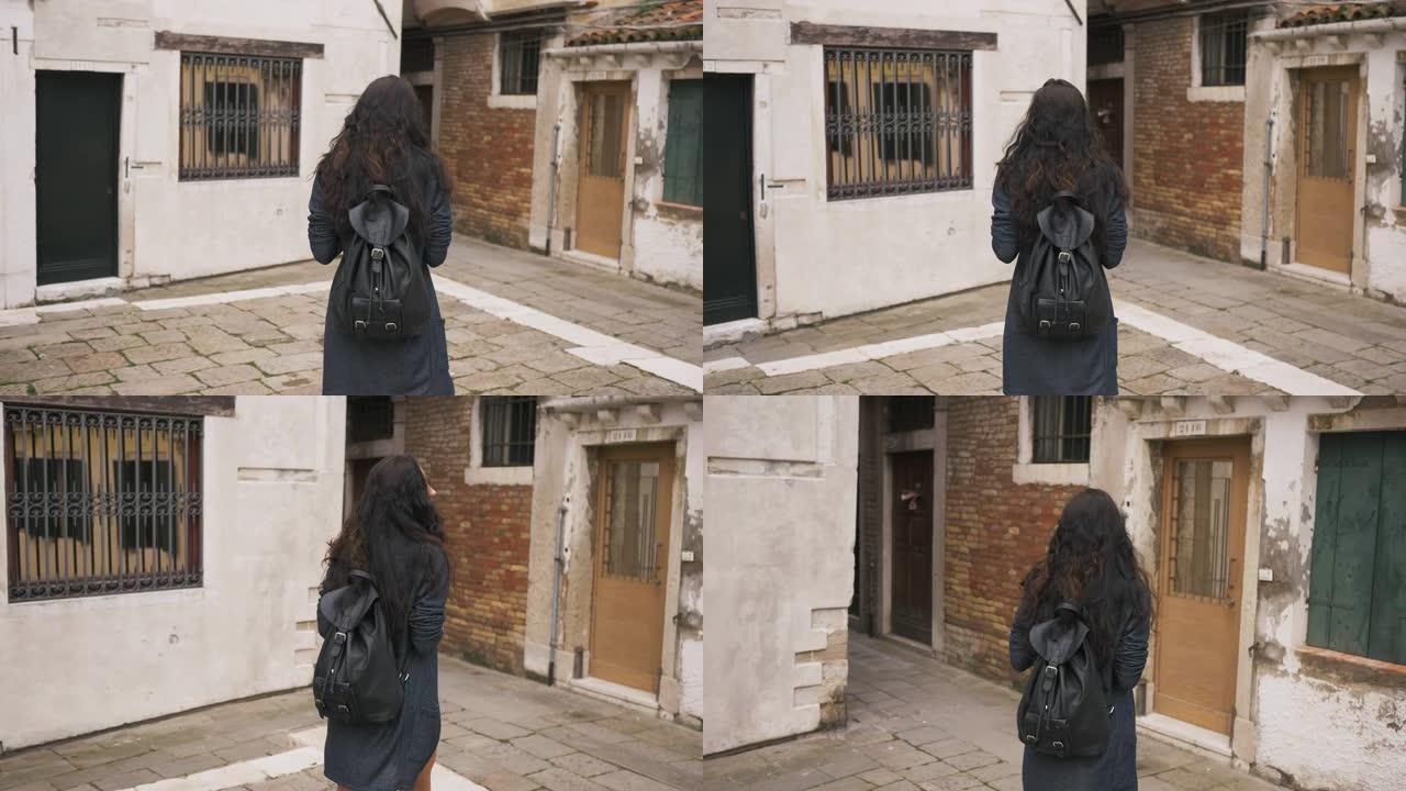 迷人的女孩走过威尼斯狭窄的街道