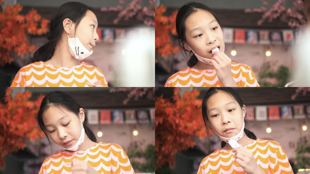 快乐的亚洲女孩在日本餐厅吃冰淇淋，有家庭生活方式的概念。