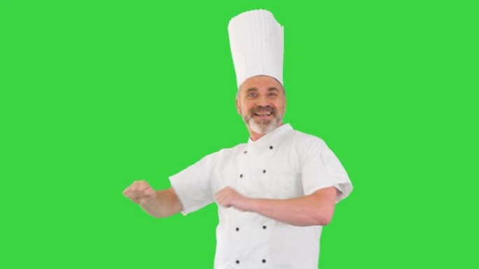 成熟的厨师，留着胡须，穿着白色制服，在绿色屏幕上跳舞，色键