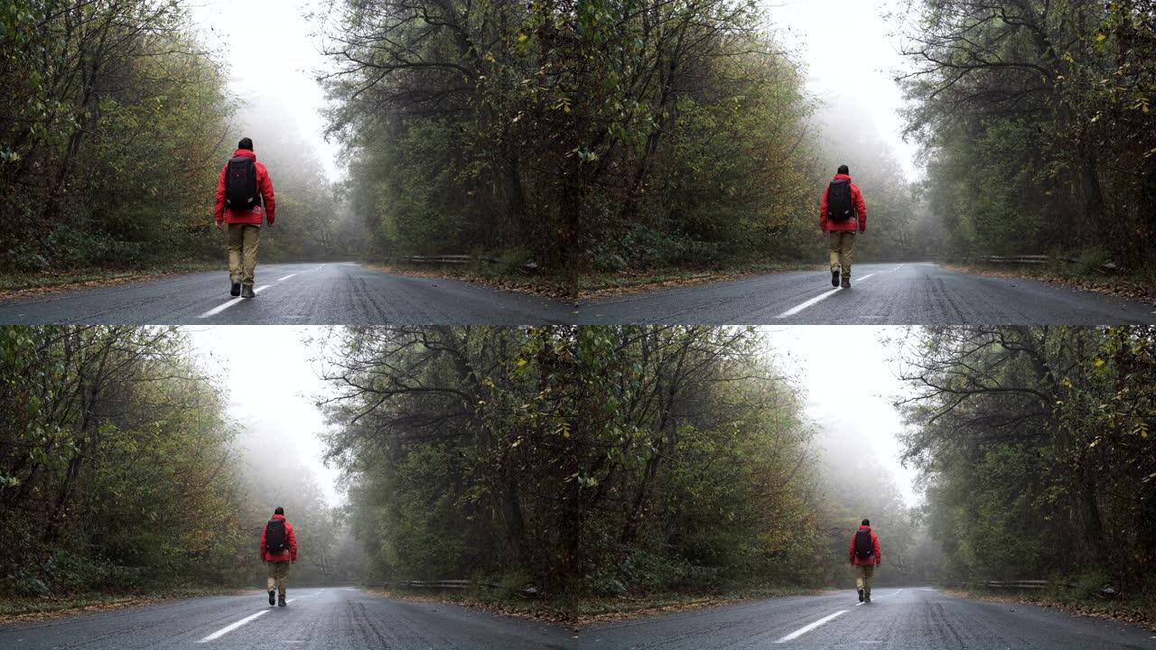 穿着红色夹克的无忧无虑的游客在空荡荡的雾蒙蒙的路上平静地行走