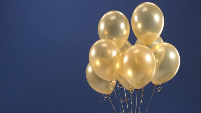 装饰元素-金色气球-出现并徘徊在视频中，作为假期的惊喜: 情人节，生日，圣诞节或新年在蓝色背景上。