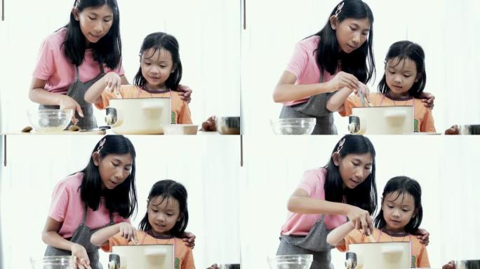 亚洲女孩教姐姐如何在家制作橙色果冻，生活方式概念。