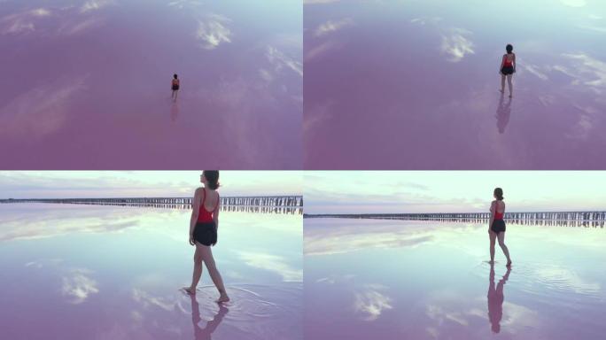 在乌克兰粉红色盐湖上行走的妇女的风景鸟瞰图