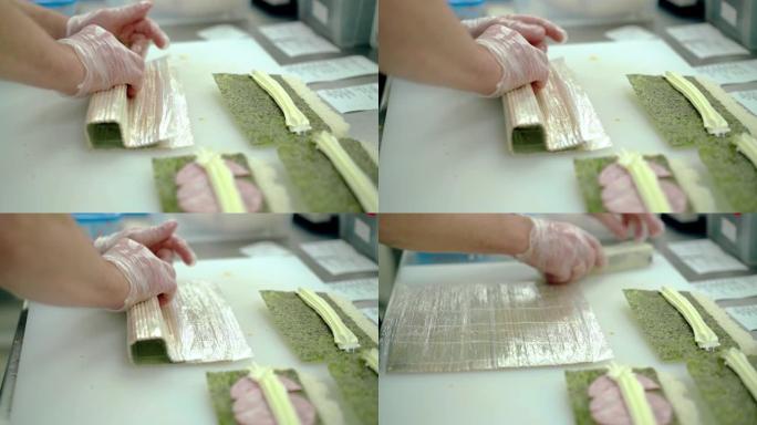 库克准备一个日本卷，用垫子把米饭裹在外面。