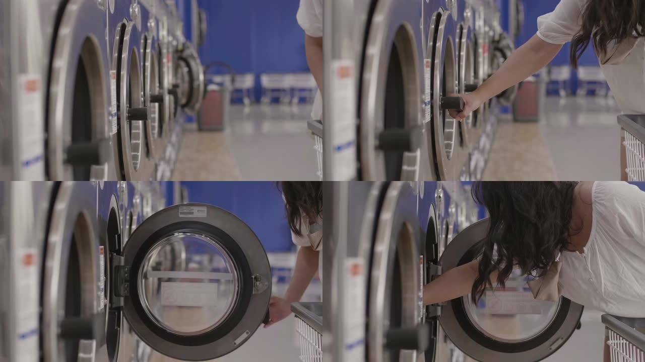 自助洗衣店装载洗衣机的年轻女子。