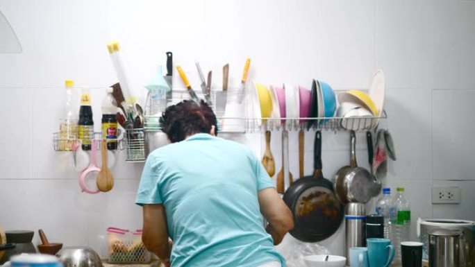 亚洲老年人在家做饭时在厨房洗碗，生活方式理念。