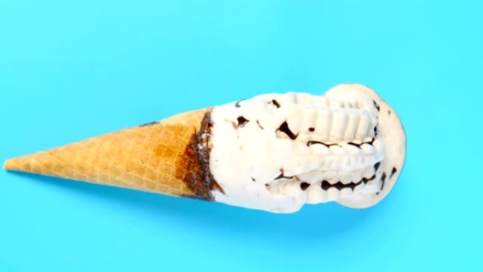 奶茶风味冰淇淋蛋卷融化在蓝色背景上的延时