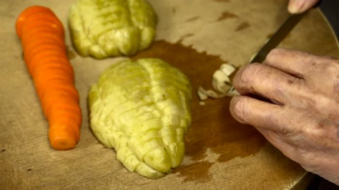 高级成年妇女在砧板上切泡菜的特写