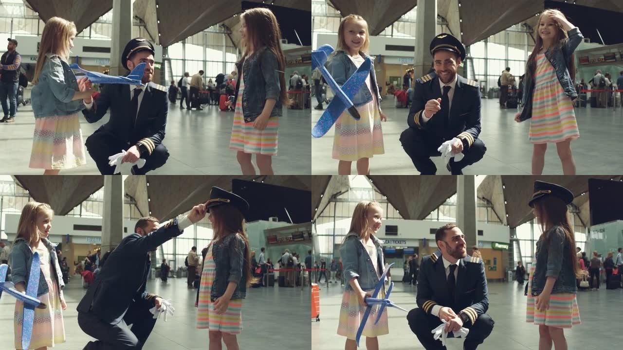 快乐的小女孩在机场航站楼从爸爸飞行员那里拿礼物，看起来开心又笑。