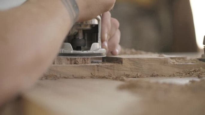 木匠使用手动电动铣刀工作。木工加工木板