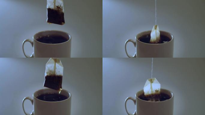 不露面的人酿造红茶，将茶袋放在室内灰色背景的白色杯子中。袋泡茶自然光慢动作复制空间文本的特写正视图。