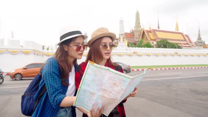 女人和朋友在看地图。亚洲女人喜欢在泰国唐人街旅行