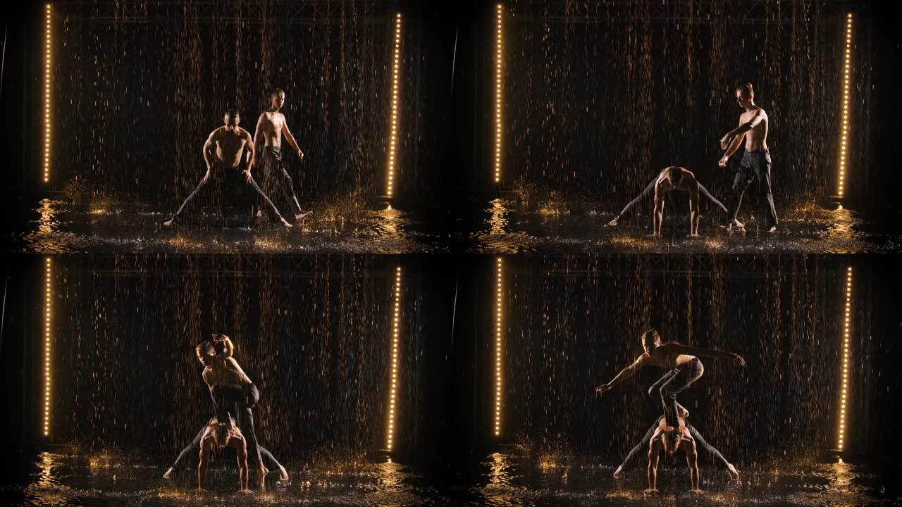 两个杂技演员在雨中表演。男人在慢动作中倒立并保持平衡