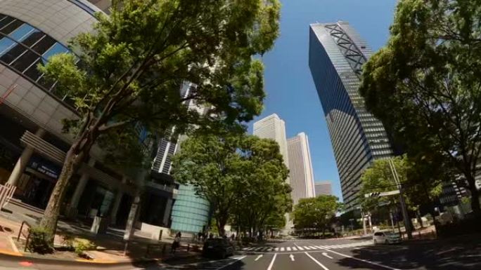 开车穿过城市的摩天大楼。巡航东京金融区新宿。