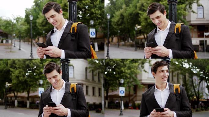 在街中央，他的智能手机上输入了一些东西，洋溢着灿烂的笑容