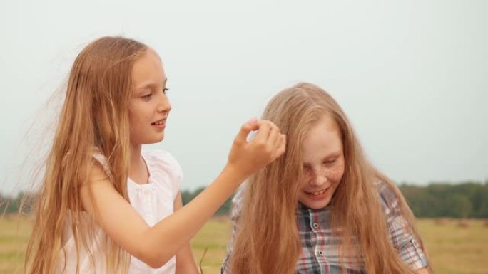 女孩触摸女性朋友户外的头发