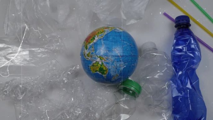 停止塑料污染。被塑料垃圾包围的地球。塑料瓶，鸡尾酒管，包装，袋子。世界环境日。时间流逝。带有乌克兰西
