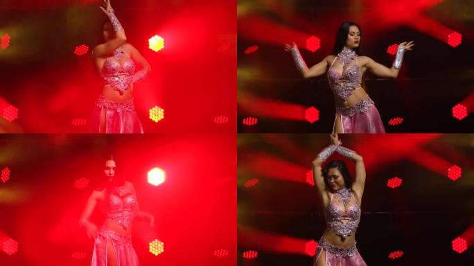 亚洲舞者在舞蹈中充满激情，表现出身体的优雅和性感。穿着时髦的亚洲服装的年轻女孩。在带有烟雾和红色霓虹