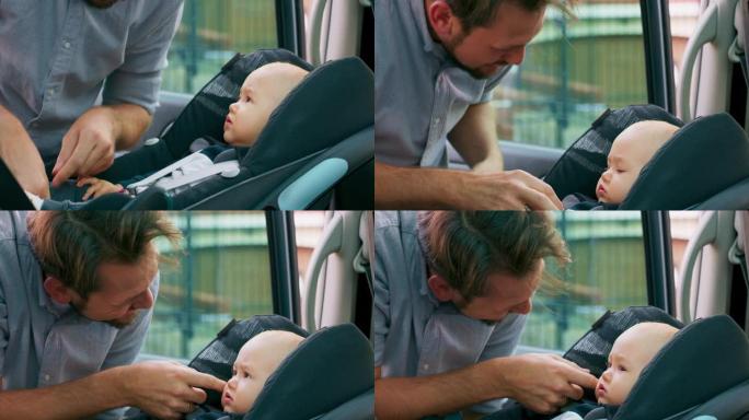 车内摄像头。特写男婴坐在车内的婴儿汽车座椅上。年轻的大胡子父亲检查婴儿系好的安全带，微笑并与他交谈，