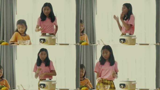 亚洲孩子在网上观看如何在家一起制作橙色果冻。
