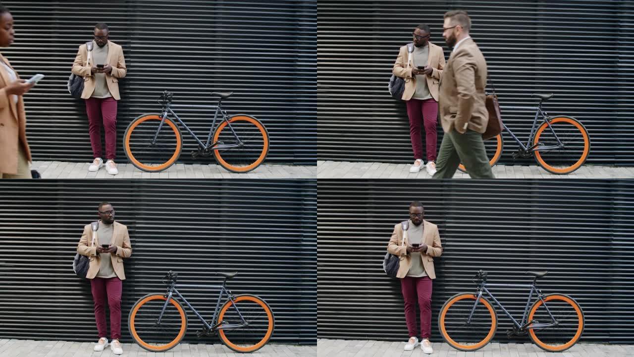 非洲裔美国人站在自行车上并使用智能手机