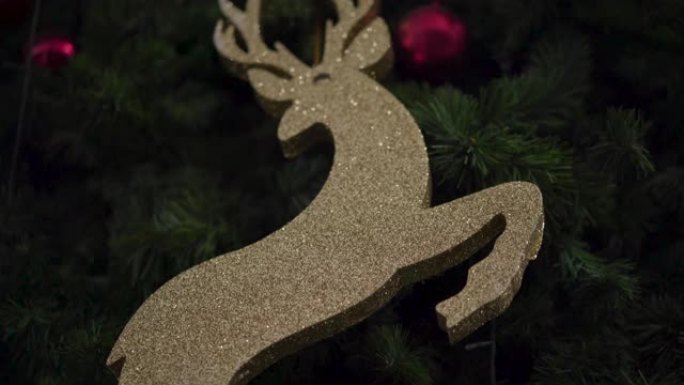 4k驯鹿装饰图挂在圣诞树上。金色闪光，装饰球，圣诞快乐，新年快乐，家庭团聚活动，礼品玩具礼物，假日周