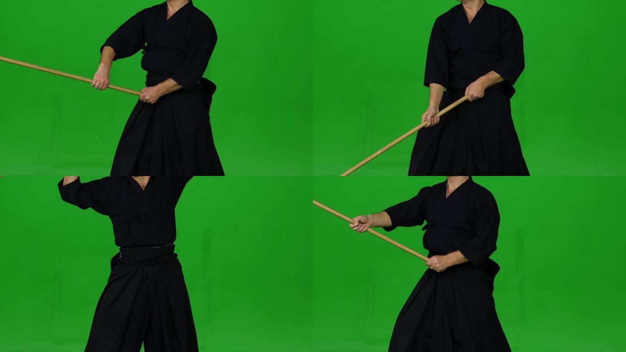 男性剑道战士在绿屏上与竹子博肯一起练习武术。特写