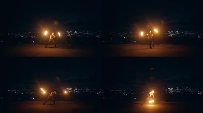 年轻的金发男子在半夜用两支燃烧的火把跳舞，黑色背景下的城市天际线。
