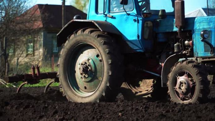 拖拉机在田里耕种和切割犁沟。村里黑土田里的拖拉机作业