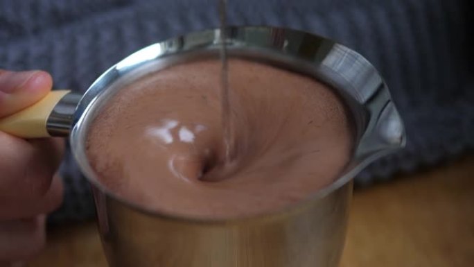 在钢罐中混合热巧克力。舒适的食物概念