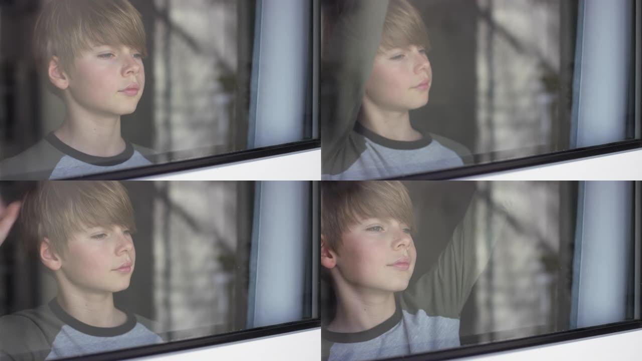 一个悲伤的微笑男孩的肖像看着窗外