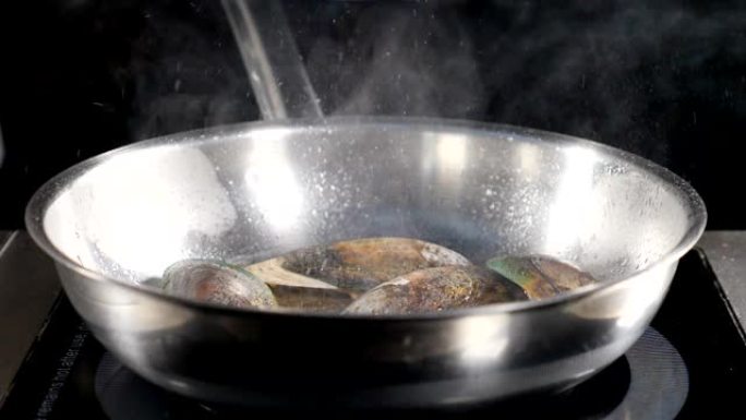 厨师烹饪海鲜。在不锈钢锅中准备海鲜的特写。慢动作。酱汁蔬菜贻贝。美味的食物视频。高清