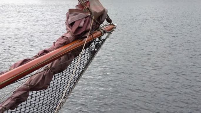 帆船上的帆船桅杆，背景为索具细节和水