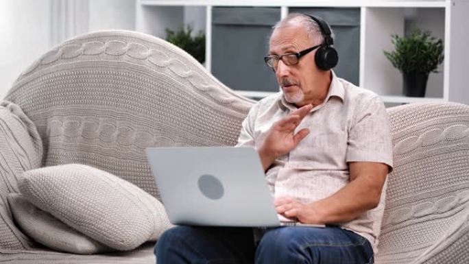 现代70年代老人戴着耳机进行在线视频通话。在红色乌鸦4k电影摄像机上拍摄