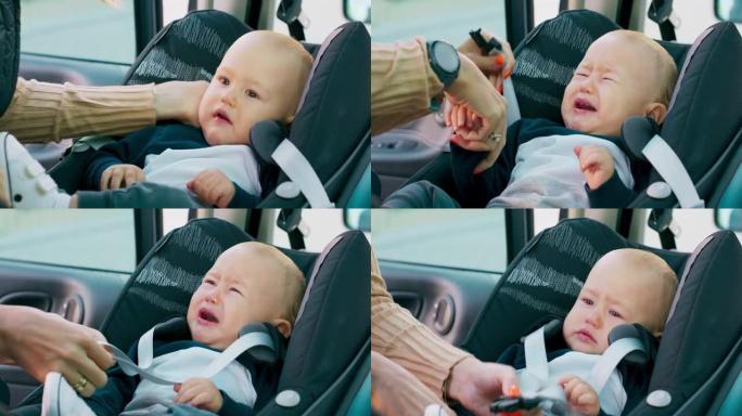 车内摄像头特写婴儿汽车安全座椅男婴出现在他母亲的手上，他把婴儿放在婴儿汽车安全座椅婴儿正在哭泣的母亲