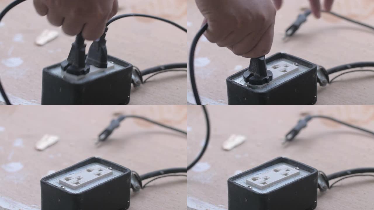 一名男子将电线插入插座以节省能源
