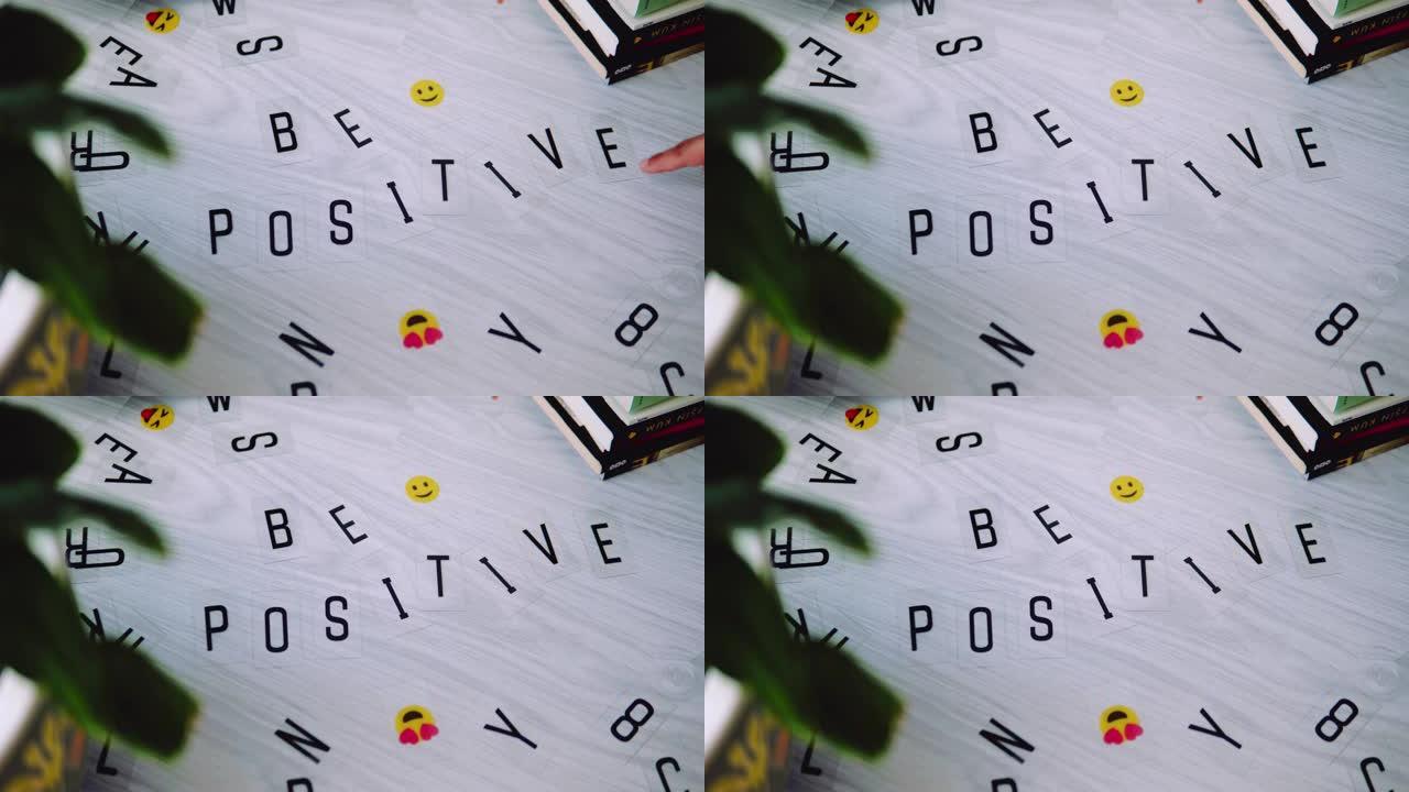 女性手将字母放在一起，并写下 “积极” 一词