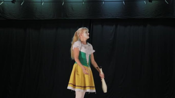 女小丑在舞台上玩杂耍